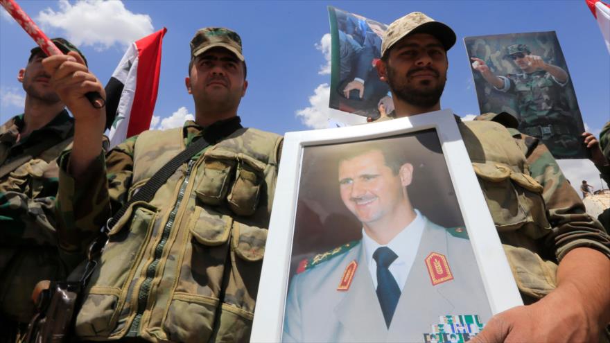 Soldados sirios portan el retrato del presidente Bashar al-Asad en Hayar al-Aswad, 24 de mayo de 2018.