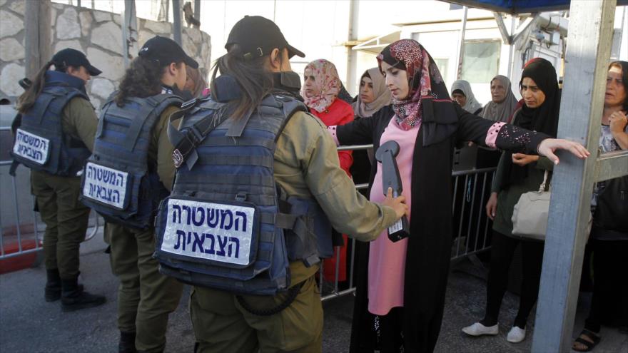 Mujeres palestinas son revisadas en un puesto de control israelí entre las ciudades de Beit Lahm (Belén) y Al-Quds (Jerusalén), 18 de mayo de 2018.