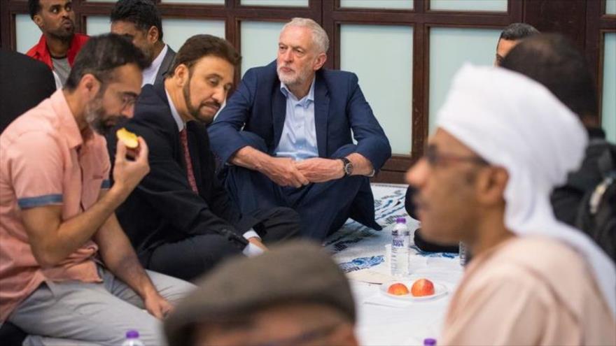 El líder del Partido Laborista británico (PL), Jeremy Corbyn (centro), participa en la ruptura del ayuno en la mezquita de Al-Manaar, Londres, 4 de junio de 2018.