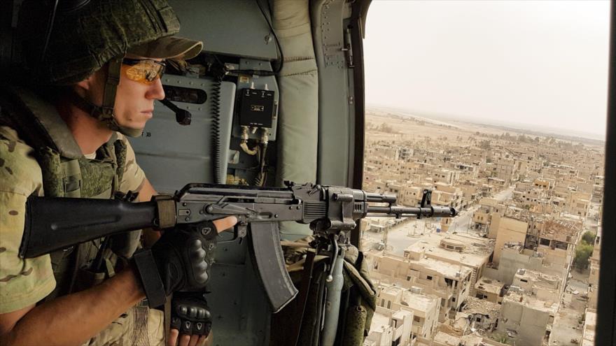 Un soldado ruso vigila en un helicóptero militar sobrevolando la ciudad siria de Palmira.