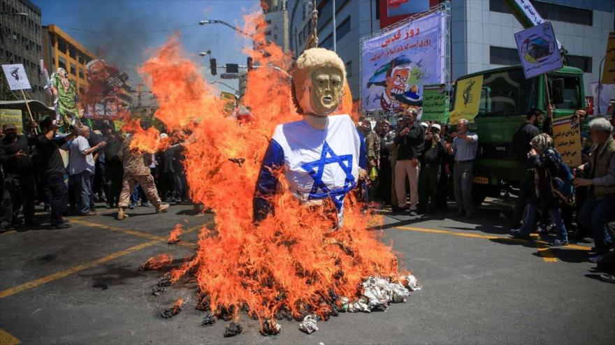 Los manifestantes iraníes en Teherán en un acto simbólico incendian un efigie de Trump, vestido de la bandera israelí, 8 de junio de 2018.