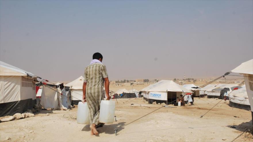 Un refugiado transporta bidones de agua en el campo de refugiados Al-Hawl en la provincia siria de Al-Hasaka, 24 de octubre de 2016.