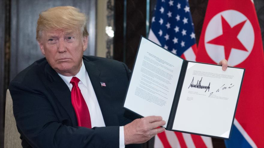El presidente de EE.UU., Donald Trump, muestra a los periodistas el acuerdo que firmó con Corea del Norte en Singapur, 12 de junio de 2018.