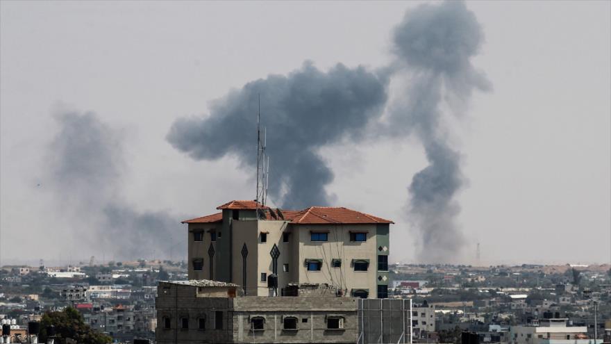 Se ve desde Rafah cómo se levanta humo sobre los edificios tra un ataque aéreo israelí en La Franja de Gaza, 9 de mayo de 2018.