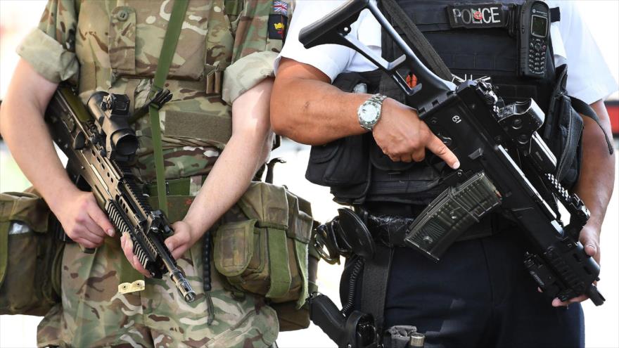 Un soldado del Ejército británico patrulla con un policía armado cerca de las Casas del Parlamento en el centro de Londres, 24 de mayo de 2017.