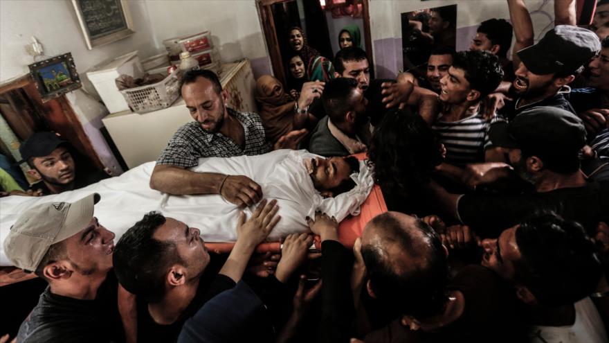 Palestinos lloran ante el cuerpo de un joven asesinado por las fuerzas de guerra israelíes, en la ciudad de Gaza 18 de junio de 2018.