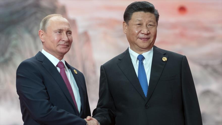 El presidente ruso, Vladimir Putin, (izq.), estrecha la mano de su par chino, Xi Jinping, en un evento en Qingdao, China, 10 de junio de 2018.