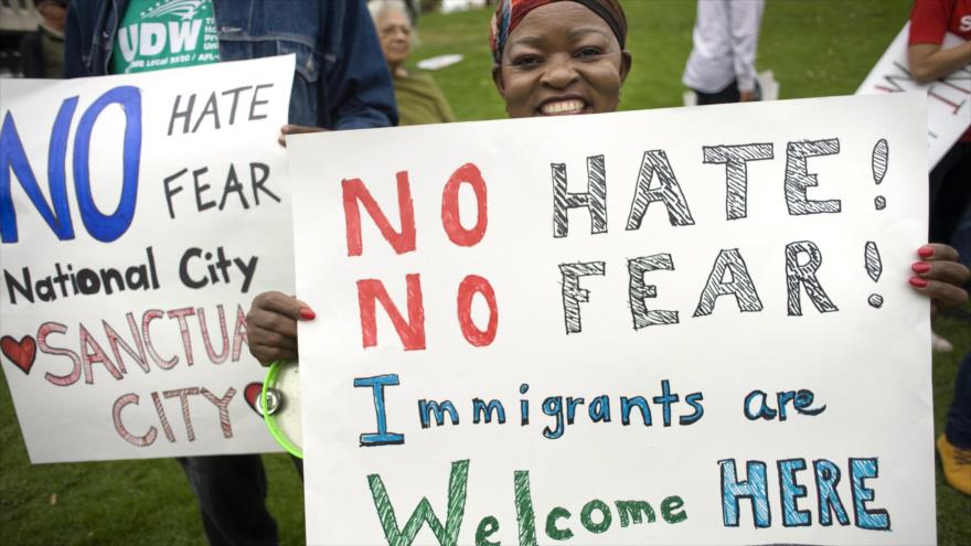Una mujer sostiene un cartel durante una manifestación de apoyo a las familias migrantes que han sido separadas.
