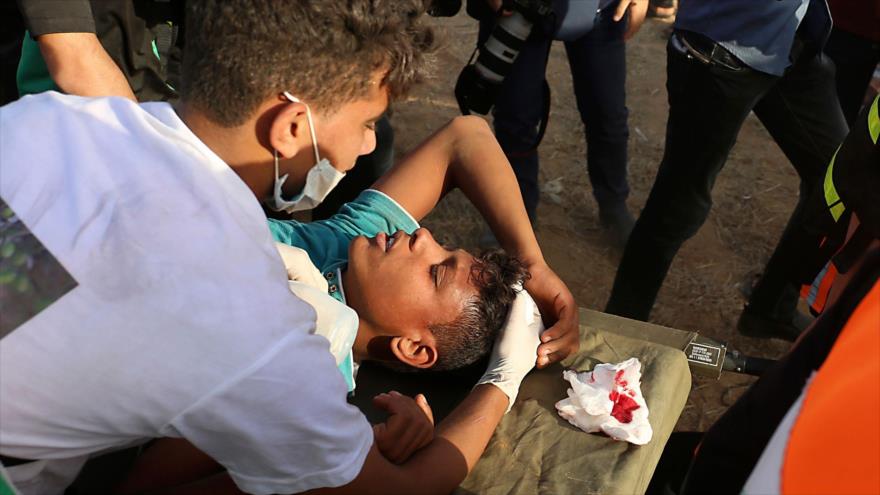 Manifestantes palestinos trasladan a un joven herido por disparos israelíes en la Franja de Gaza, 22 de 2018.