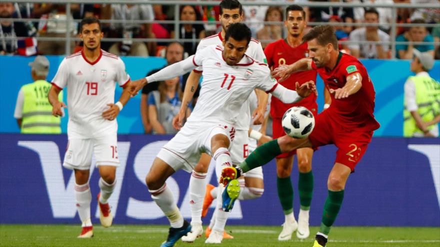 El jugador iraní Vahid Amiri compite por el balón con el portugués Adrien Silva durante el partido de fútbol del Grupo B de Copa Mundial. Fuente: AFP