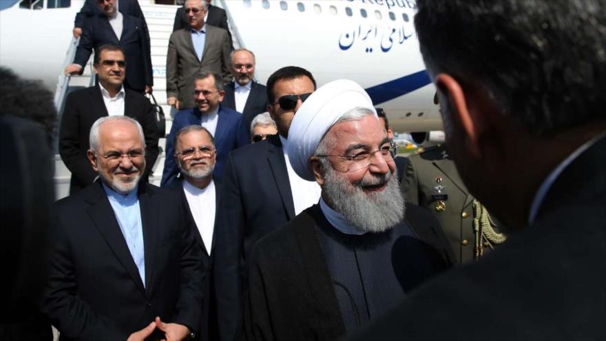 El canciller iraní, Mohamad Yavad Zarif (izqa.) junto al presidente Hasan Rohani, llega a Suiza, 2 de julio de 2018.