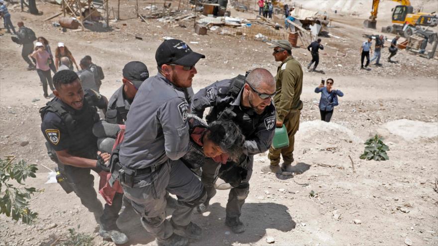 Fuerzas israelíes arrestan a una manifestante en una protesta contra la demolición en la aldea Jan al-Ahmar, 4 de julio de 2018.
