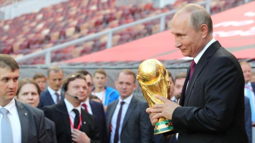 El presidente ruso, Vladimir Putin, sostiene la copa del mundo en la ceremonia de inauguración del Mundial de Rusia 2018 en el estadio Luzhniki de Moscú.
