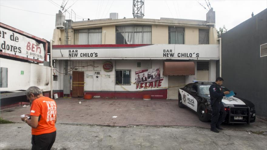 Un policía vigila un bar donde personas fueron asesinadas en un ataque simultáneo, Monterrey, capital de Nuevo León, México, 8 de julio de 2018.