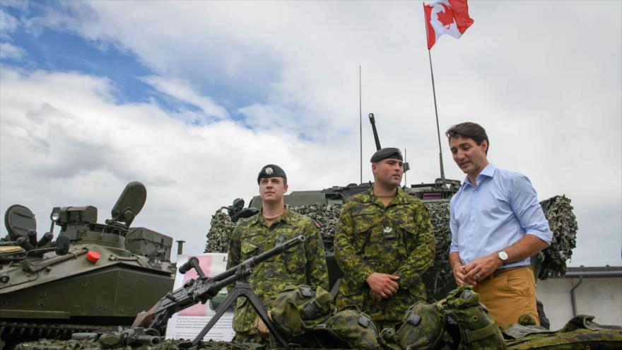 El premier de Canadá, Justin Trudeau, observa equipamiento militar junto a varios efectivos de las tropas de la OTAN en Letonia, 10 de julio de 2018.