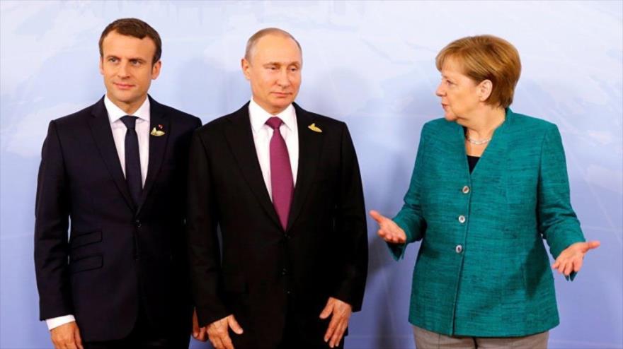 De izq. a dcha.: El presidente francés, Emmanuel Macron, su par ruso, Vladimir Putin, y la canciller alemana, Angela Merkel.