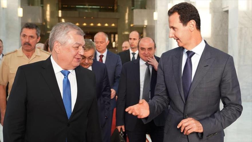 El presidente sirio, Bashar al-Asad (drcha.) y Alexander Lavrentiev, el enviado del presidente ruso, se reúnen en Damasco, 25 de julio de 2018.