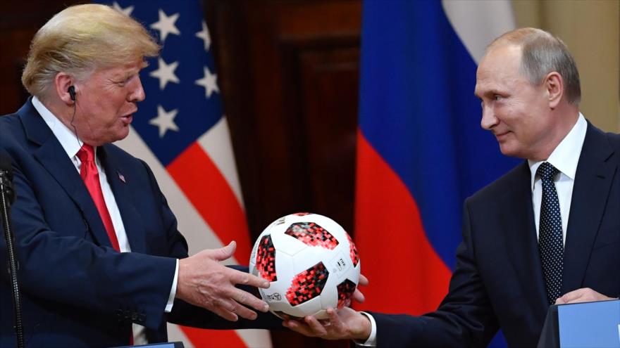 El presidente ruso, Vladimir Putin (dcha.), entrega a su par estadounidense, Donald Trump, un balón del Mundial, en Helsinki, 16 de julio de 2018.