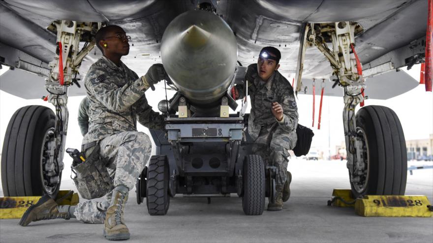 Ingenieros militares estadounidenses instalan una bomba Mk-84 sobre un bombardero F-15 Eagle Strike.