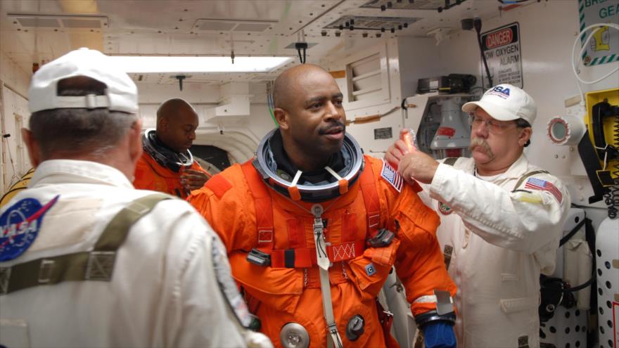 Leland Melvin (Centro), el astronauta de la NASA se prepara para una misión.