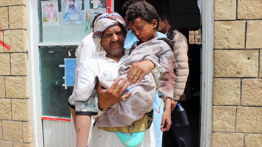 Un hombre yemení carga a un niño herido, tras un ataque aéreo saudí en la provincia de Saada, 9 de agosto de 2018. Fuente: AFP