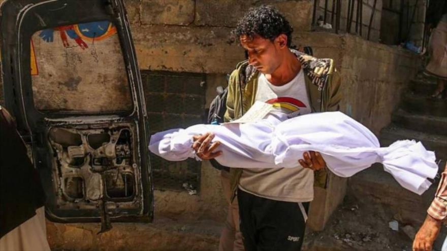 Un hombre porta el cuerpo de un niño muerto a consecuencia de un bombardeo saudí en la provincia yemení de Taiz.