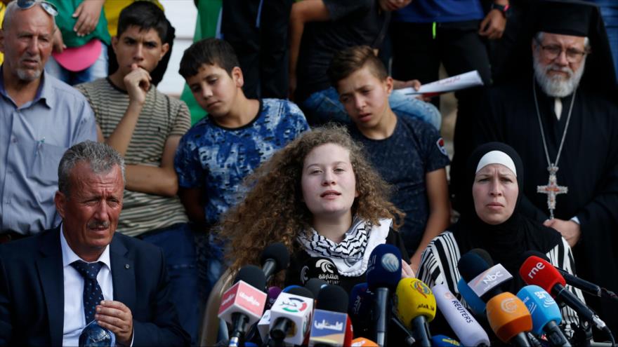 La joven palestina Ahed Tamimi (C) sentada en medio de sus padres ofrece una conferencia de prensa, 29 de julio de 2018. (Foto: AFP)