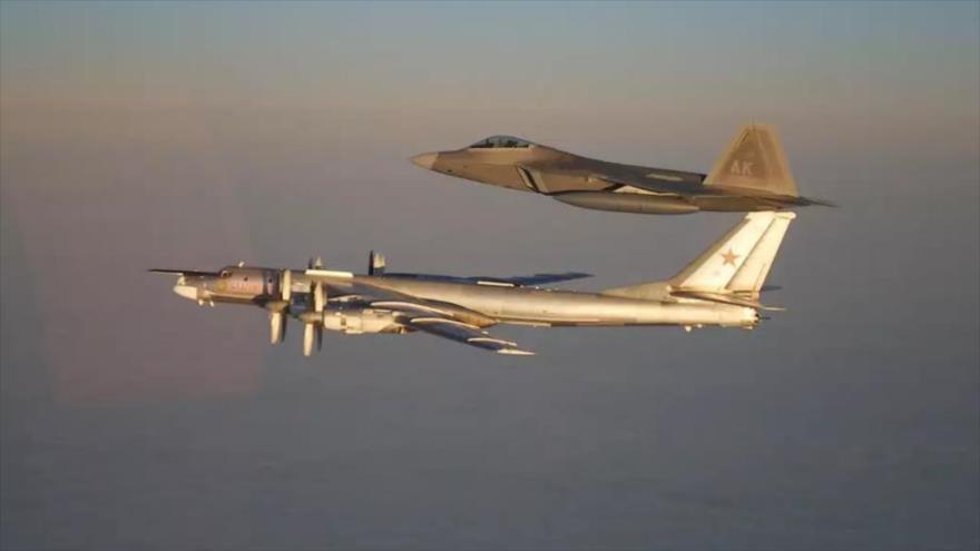 Un cazabombardero estadounidense F-22 Raptor acompaña a un bombardero nuclear ruso Tupolev Tu-95.