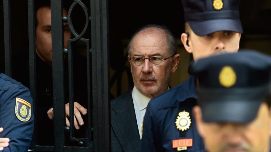 El exvicepresidente del Gobierno español, Rodrigo Rato (C), abandona su oficina mientras es escoltado por la Policía. 17 de abril de 2015. Foto: AFP.