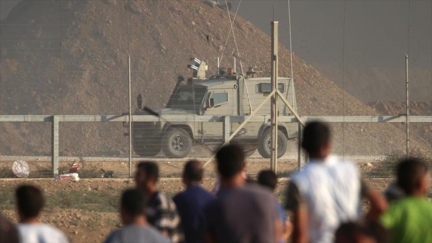 Los manifestantes palestinos observan un vehículo de las fuerzas israelíes a lo largo de la frontera con Gaza, 28 de septiembre de 2018. (Foto: AF)