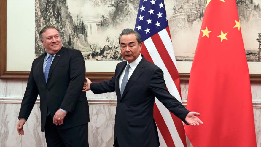 Canciller chino Wang Yi (dcha.) y su par de EE.UU., Mike Pompeo, antes de mantener una reunión bilateral en Pekín, 8 de octubre de 2018. (Foto: AFP)