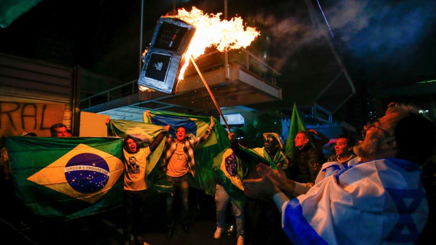 Seguidores del ultraderechista Jair Bolsonaro incendian un modelo de dispositivo de votación electrónico, Sao Paulo, 7 de octubre de 2018. (Foto: AFP).