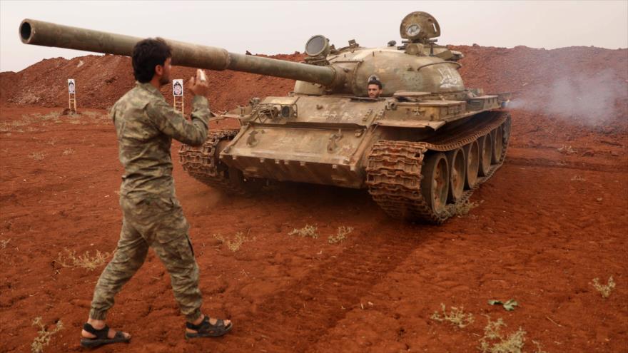 Llamados rebeldes sirios del Frente de Liberación Nacional (FLN) llevan un tanque y sus armas pesadas en las afueras de Idlib. 9 de octubre de 2018. (Foto: AFP)