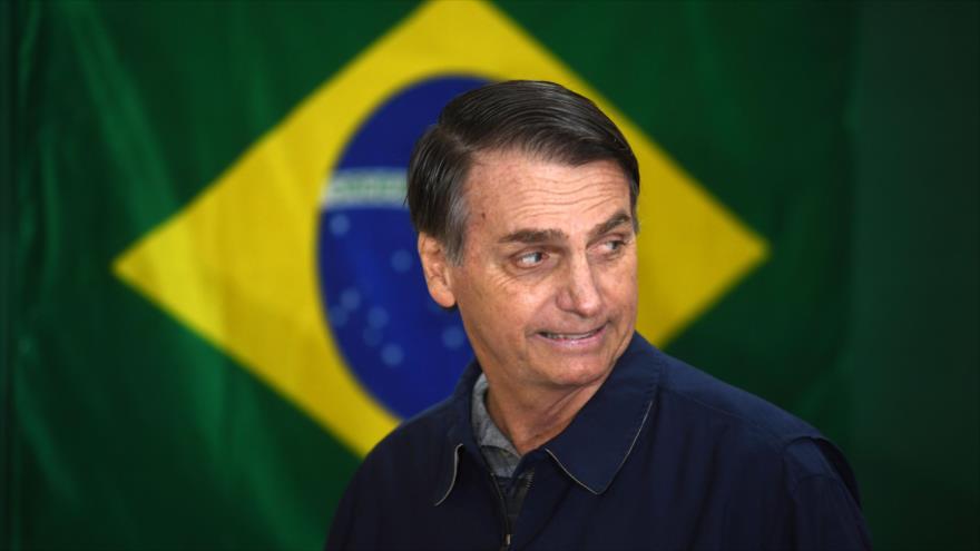 Jair Bolsonaro, presidente electo de Brasil, camina frente a la bandera nacional durante los comicios, Río de Janeiro, 7 de octubre de 2018. (Foto: AFP)