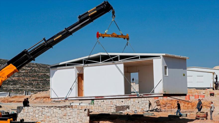 Obreros israelíes instalan nuevas casas móviles en el asentamiento, conocido como Amichai, en la Cisjordania ocupada, 21 de febrero de 2018.