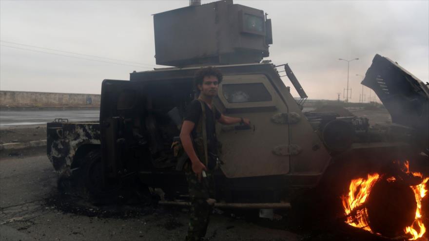 Un combatiente de Ansarolá inspecciona un vehículo blindado quemado cerca de la ciudad yemení de Al-Hudayda, 13 de septiembre de 2018. (Foto:AFP) 
