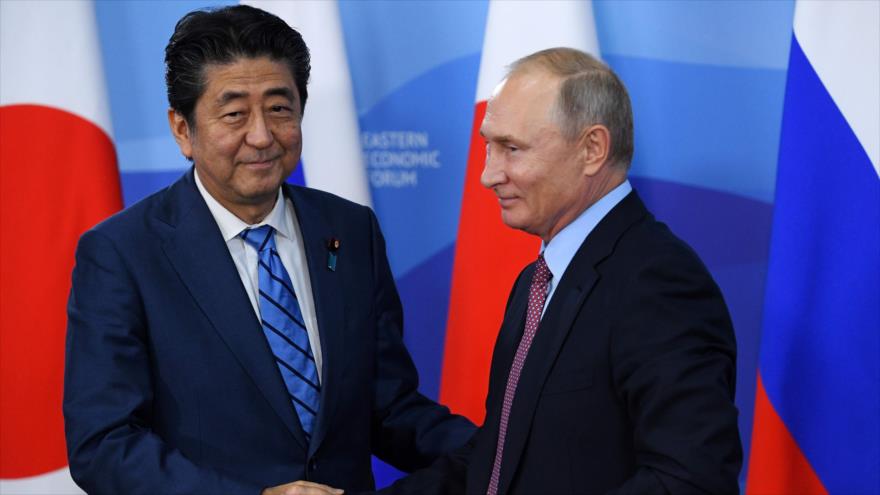 El presidente ruso, Vladimir Putin (dcha.) y le da mano al primer ministro japonés, Shinzo Abe, en Vladivostok, 10 de septiembre de 2018. Foto: AFP.

