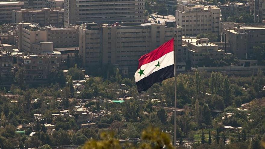 Bandera nacional siria enarbolada en una plaza en Damasco.