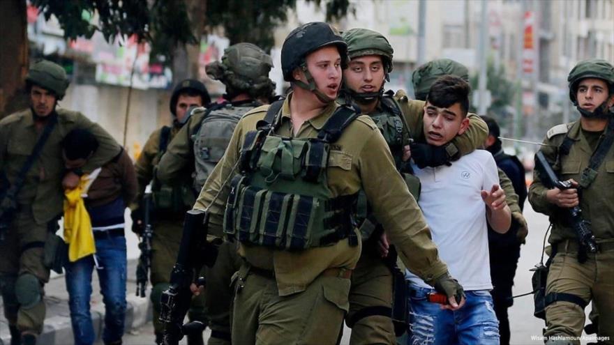 Soldados israelíes detienen a un niño palestino en la Cisjordania ocupada, 20 de diciembre de 2018. (Foto: APAimages)