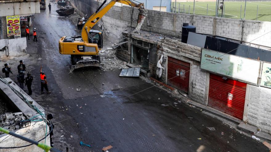 Una excavadora israelí demuele una tienda palestina en el campo de refugiados de Shuafat, en Al-Quds (Jerusalén), 21 de noviembre de 2018. (Foto: AFP)