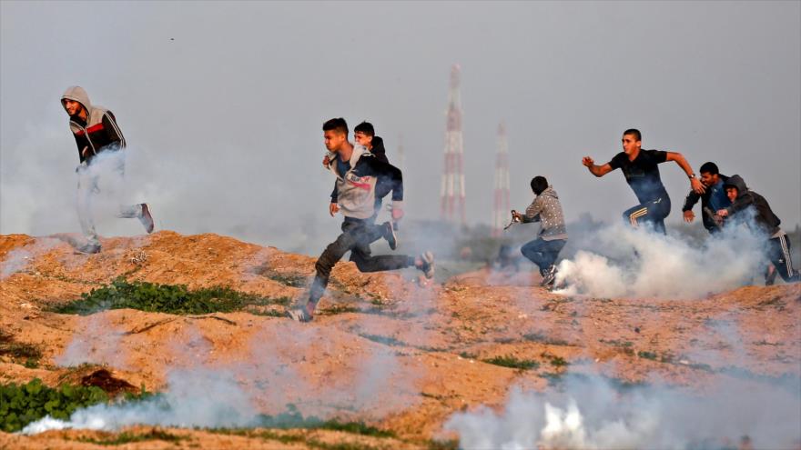 Manifestantes palestinos son atacados con gas lacrimógeno por parte de soldados israelíes, 30 de noviembre de 2018. (Foto: AFP)