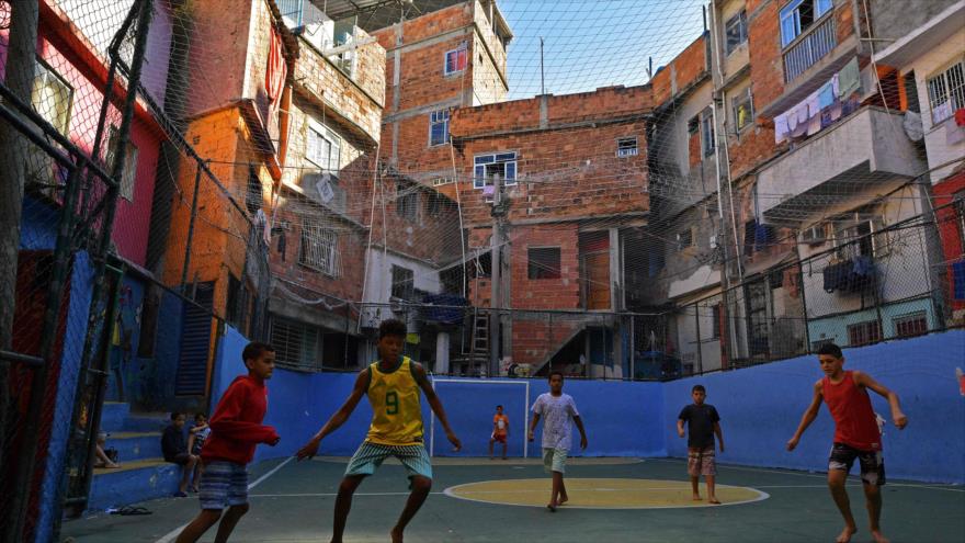 Unos niños juegan al fútbol en una de las favelas de Río de Janeiro, 27 de mayo de 2018. (Foto: AFP)