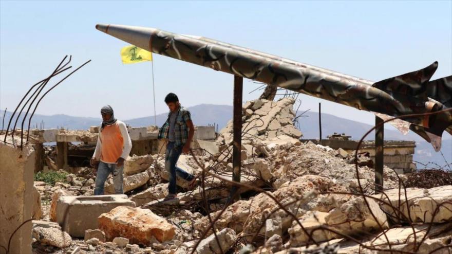 Jóvenes libaneses pasan frente a una maqueta de un cohete de Hezbolá en el pueblo de Jayam, en el sur de El Líbano.