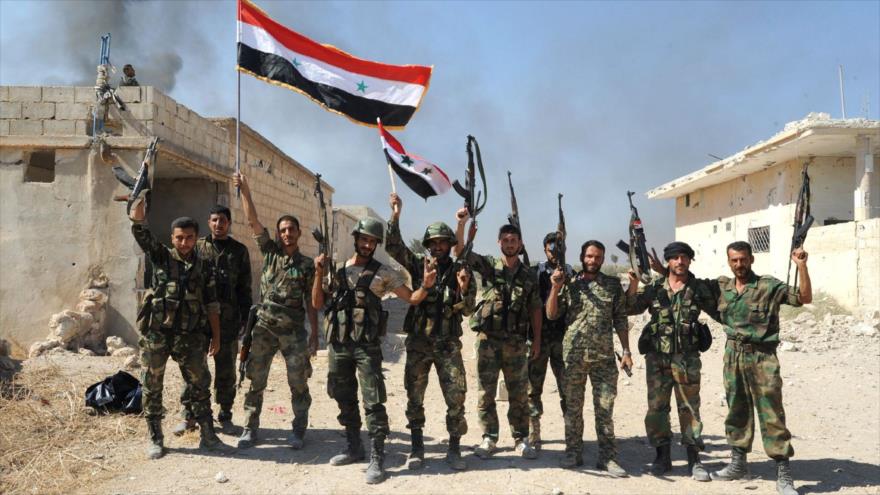 Soldados del Ejército sirio muestran gesto de victoria en la aldea de Atshan, en la provincia central de Hama. 