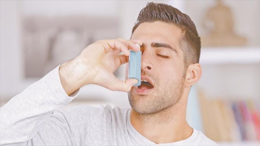 Un hombre que padece asma emplea un inhalador.