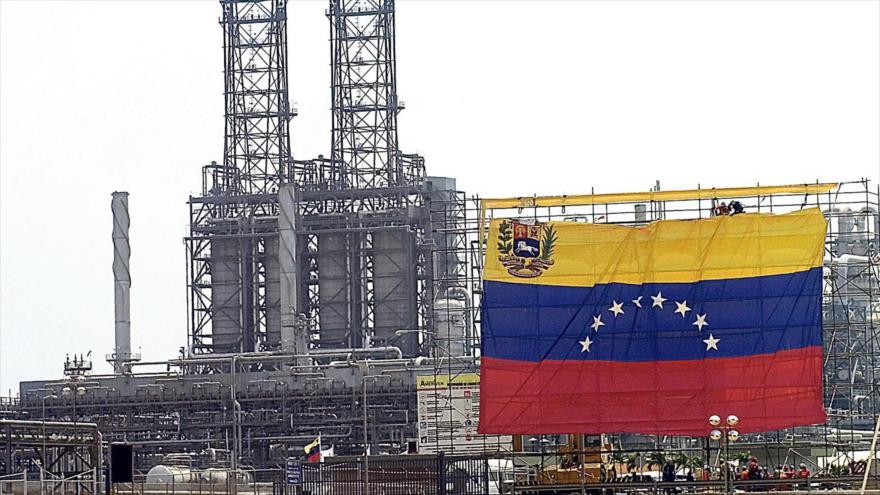 Una bandera de Venezuela cuelga de las instalaciones de una refinería de la compañía Petróleos de Venezuela (PDVSA).