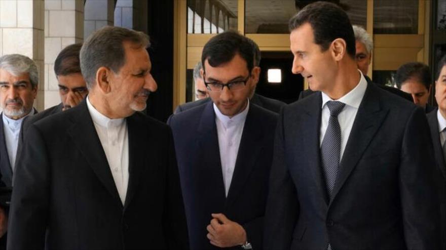 El presidente sirio, Bashar al-Asad (dcha.), habla con el vicepresidente primero iraní, Eshaq Yahanguiri, en Damasco, 29 de enero de 2019. 