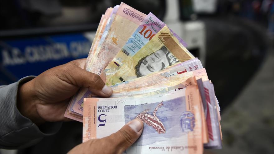 Un hombre cuenta los billetes de Bolívar en una calle de Caracas, 29 de enero de 2019. (Foto: AFP).