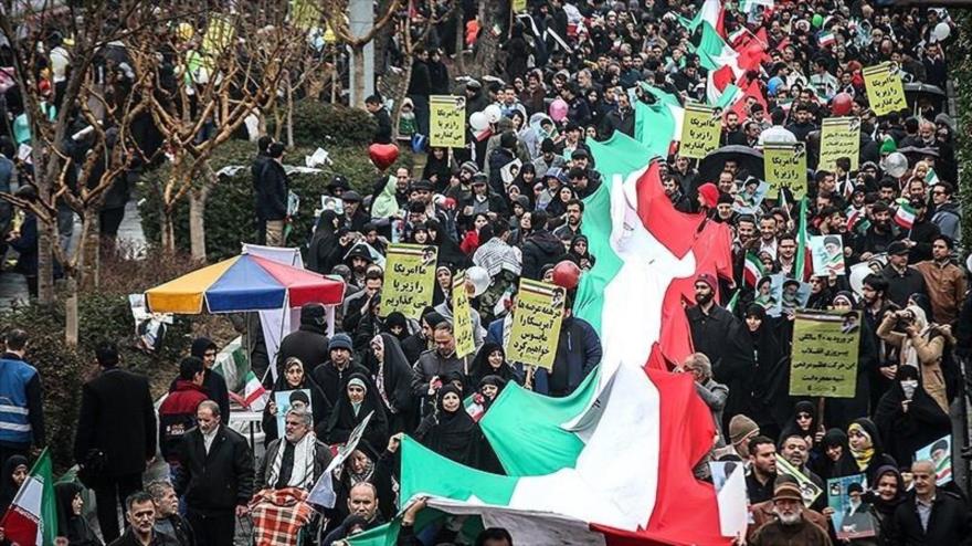 Ciudadanos iraníes portan una gran bandera nacional en la marcha por la victoria de la Revolución Islámica en Teherán, capital persa, 11 de febrero de 2019.