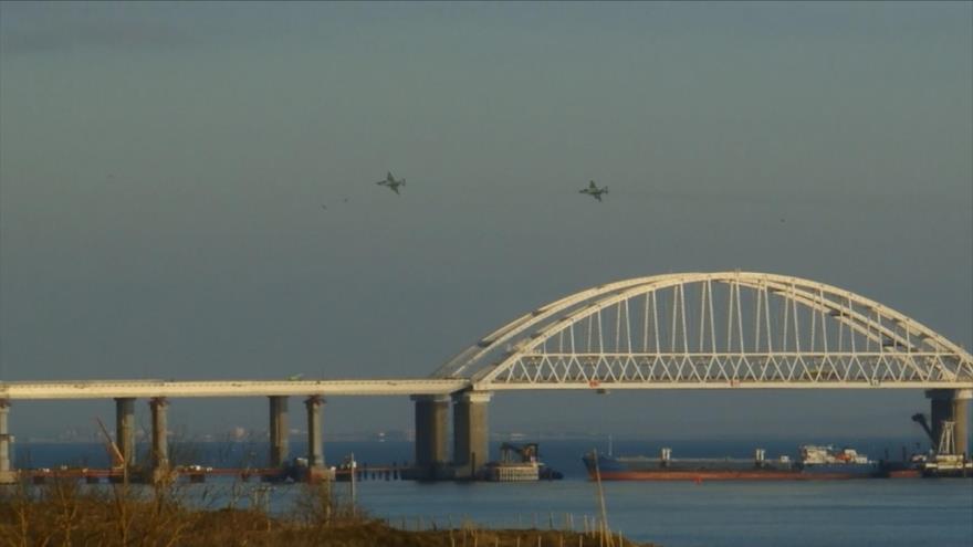 Un avión ruso sobrevuela el puente de Crimea que cruza el estrecho de Kerch, que comunica el mar Negro con el mar de Azov, 26 de diciembre de 2018. (Foto: AFP)